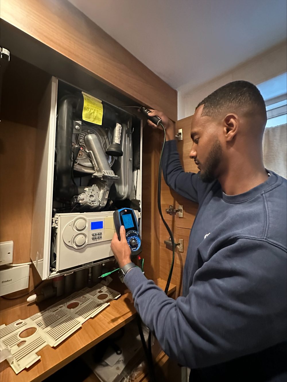 Gas engineer testing a boiler with a flue gas analyser